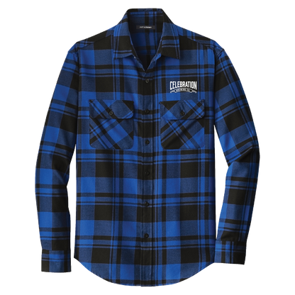 A long-sleeve button-up flannel shirt in a blue and black plaid pattern, featuring two buttoned chest pockets and a white 'CELEBRATION' logo patch on the left chest, displayed on a clean white background.